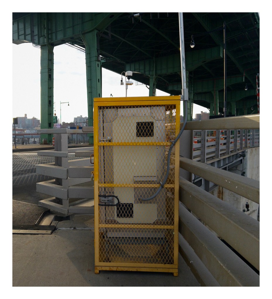 a yellow cage holds electrical equipment on a bridge