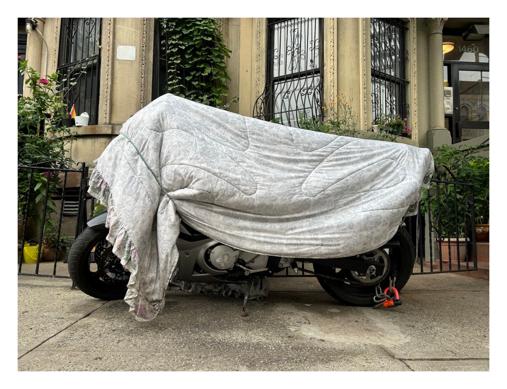 a motorcycle covered with a floral-patterned bed comforter