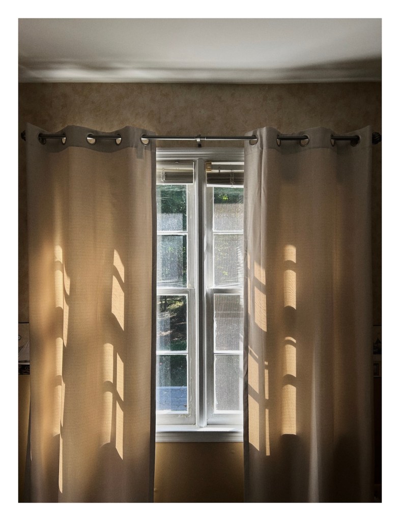 evening light comes in through pale beige curtains in a quiet room