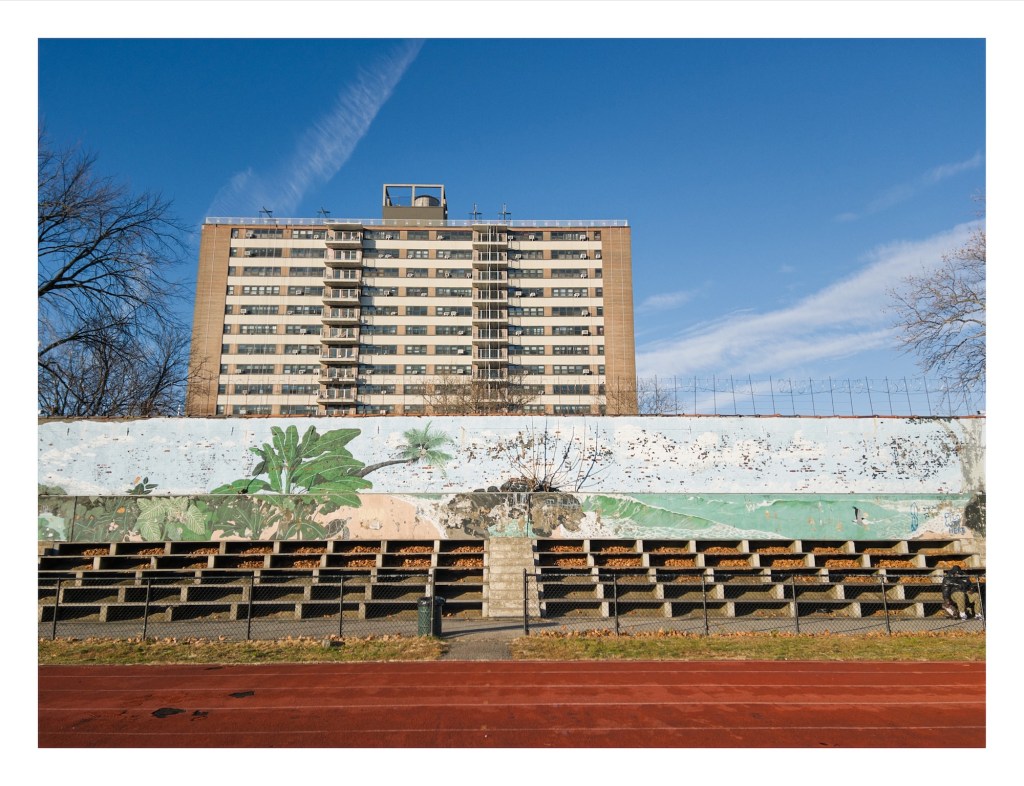 mural above the stands next to a running traack