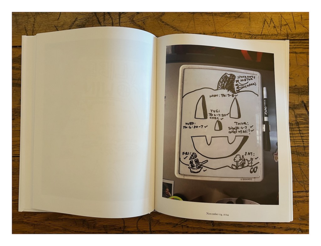 a photobook displays a whiteboard with a jack-o-lantern drawn on a weekly calendar